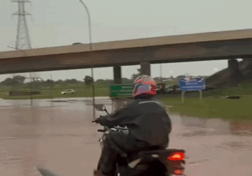 Carros e até motos se arriscam atravessando trecho de alagamento recorrente