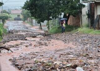Morador limpa boca de lobo com enxada para evitar alagamento de casa Morador limpa boca de lobo com enxada para evitar alagamento de casa