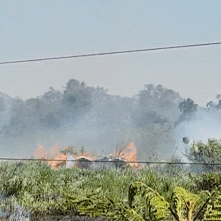 Cena corriqueira atualmente, incêndio em terreno é combatido com baldes de água