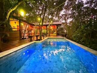 Casa se esconde entre árvores e tem até piscina no meio da mata