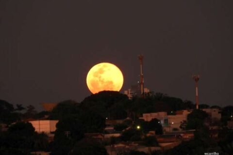 Lua cheia surge alaranjada e colore o céu de Campo Grande